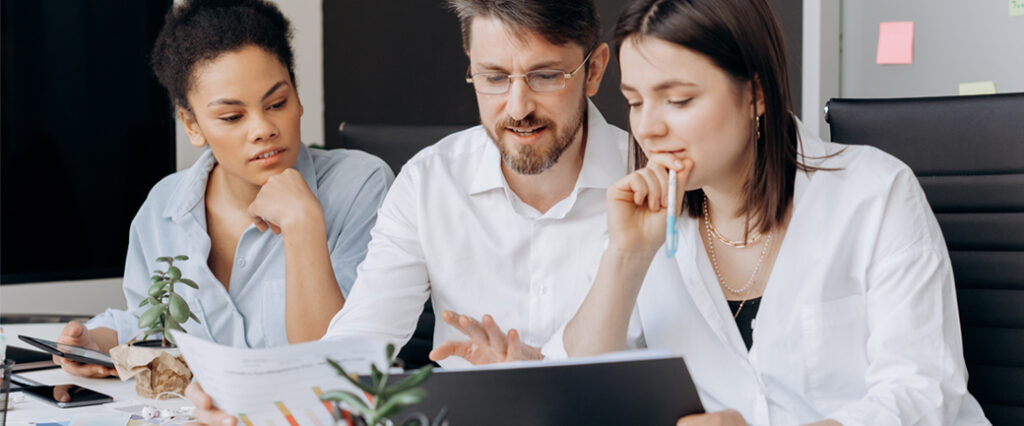 three colleagues work at a desk